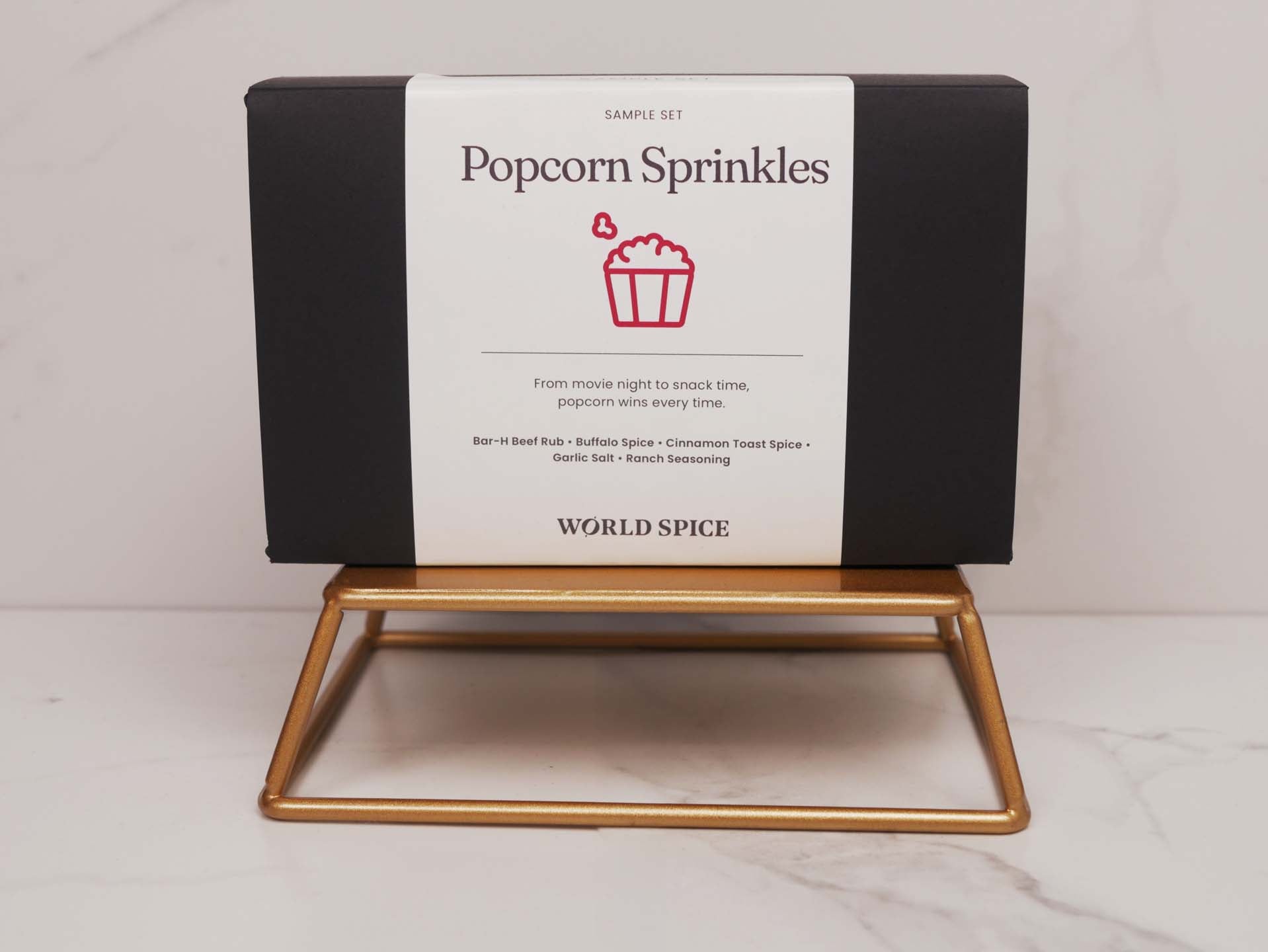 a box of popcorn sprinkles sitting on a stand